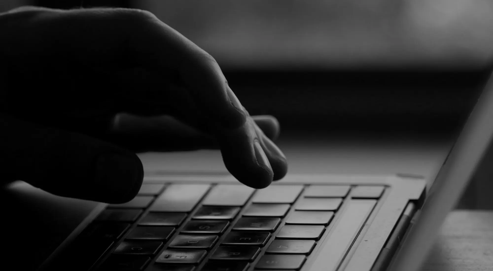 A hand on a laptop keyboard