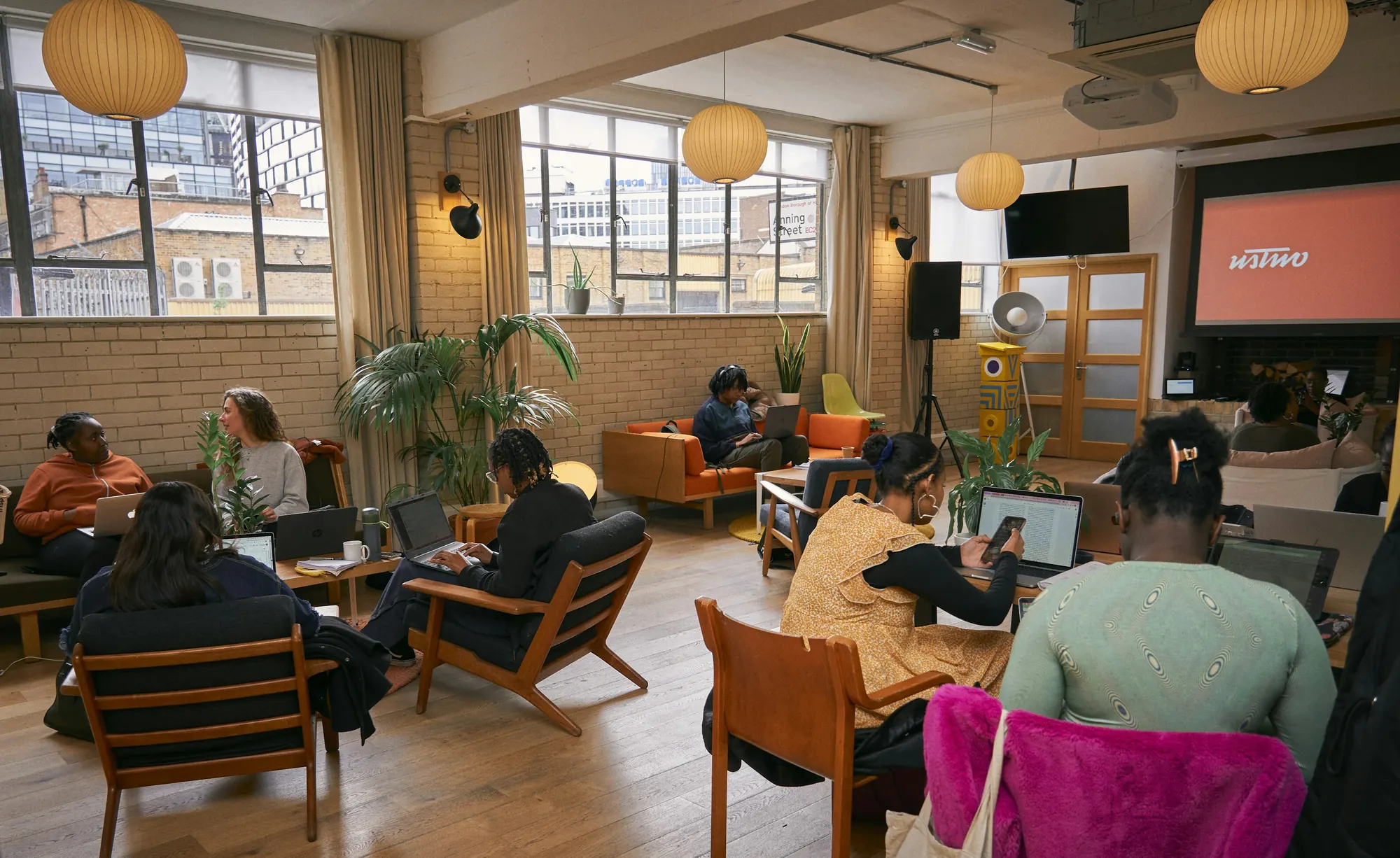People collaborating on laptops in a bright, open workspace