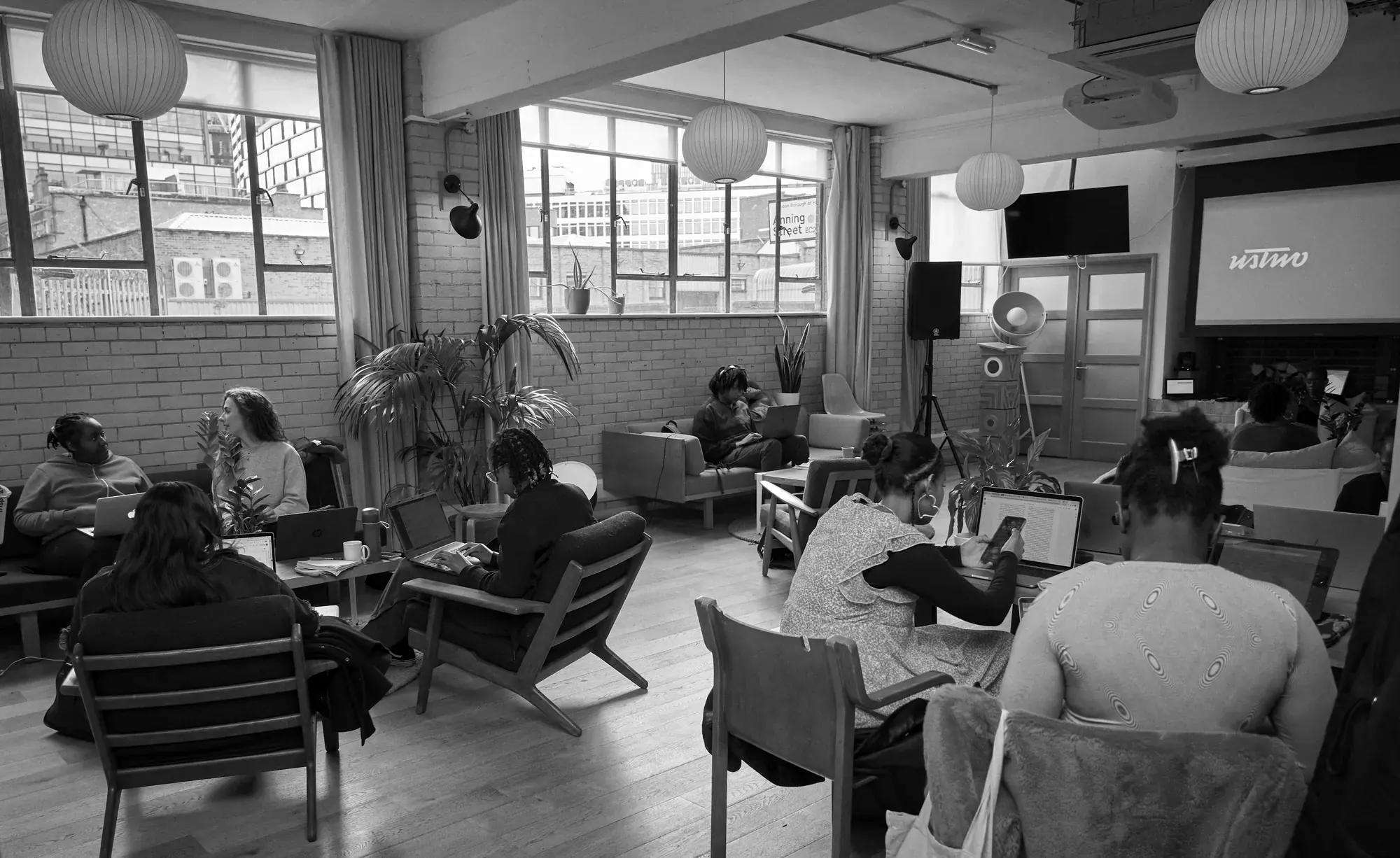 People collaborating on laptops in a bright, open workspace