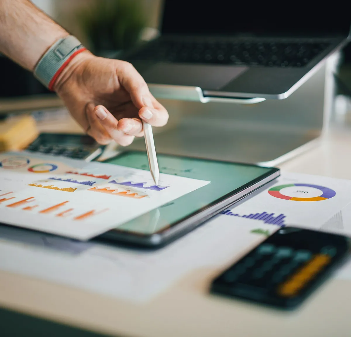 Une main et un stylet sur des graphiques