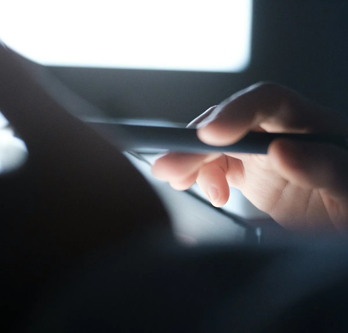 Une main sur un portable, lumière basse